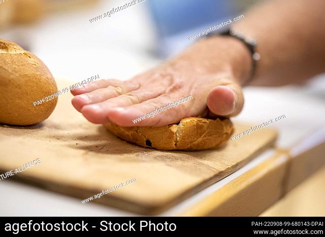 08 September 2022, Berlin: Michael Isensee, a roll tester from the Deutsches Brotinstitut e.V. (German Bread Institute), checks a roll for its crust properties...