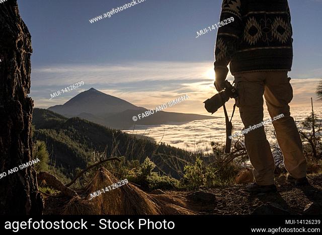 photographer man with dslr camera admiring scenic mountaing view and sky. hiker admiring stunning mountain range. tourist with camera admiring breathtaking...