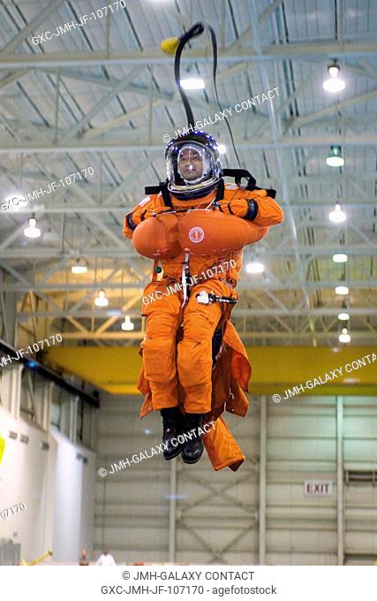 Astronaut Mark L. Polansky, STS-116 commander, attired in a training version of the shuttle launch and entry suit, simulates a parachute drop into water during...