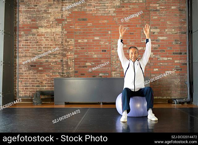 Senior man doing gore training with balance ball
