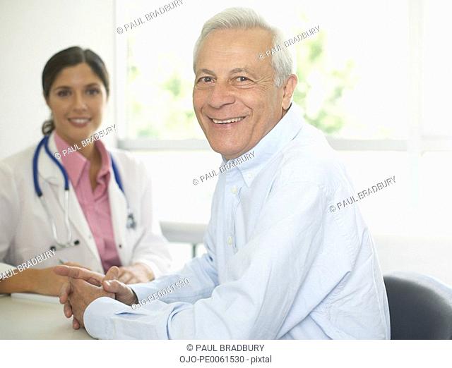 Doctor and patient sitting in office smiling