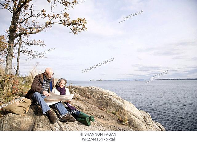 Mature couple reading a map near lake