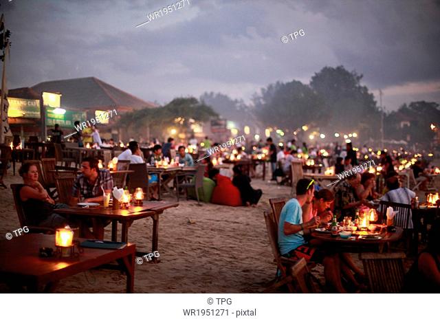 People enjoying dinner at Jimbaran Beach in Bali, Indonesia