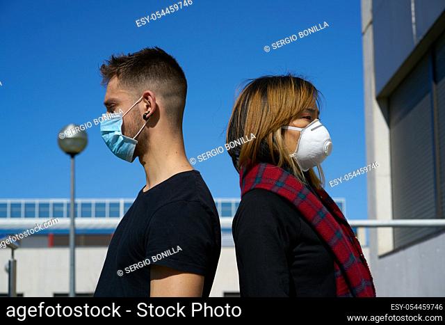 Caucasian male and Asian female wearing medical masks as a defense against a virus. The concept of Coronavirus