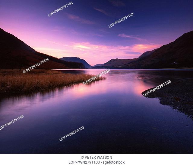 England, Cumbria, Buttermere. Looking across the still waters of Buttermere in the Lake District at sunset
