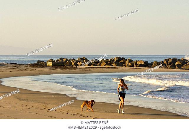 United States, California, Los Angeles, woman jogging with her dog on the Venice Beach