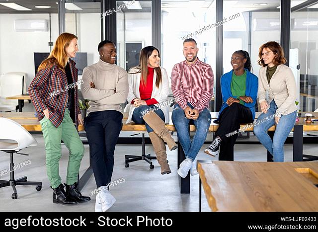 Happy multiracial businessmen and businesswomen spending time together in coworking office