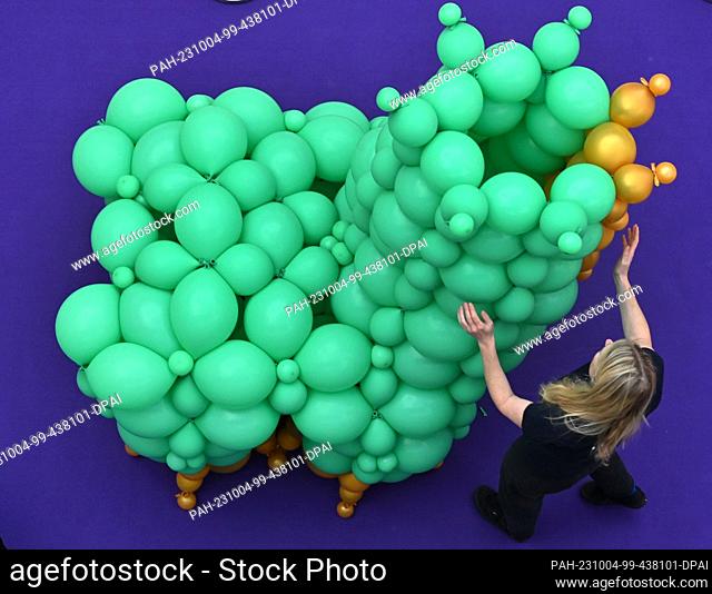 04 October 2023, Thuringia, Erfurt: Sina Greinert from Ballonetti works on setting up the ""Balloon Worlds"" exhibition in the ""Thüringen-Park"" shopping...