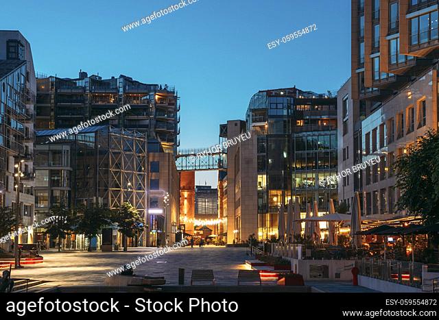 Oslo, Norway. Night View Embankment And Residential Multi-storey Houses In Aker Brygge District. Summer Evening. Residential Area Reflected In Sea Waters