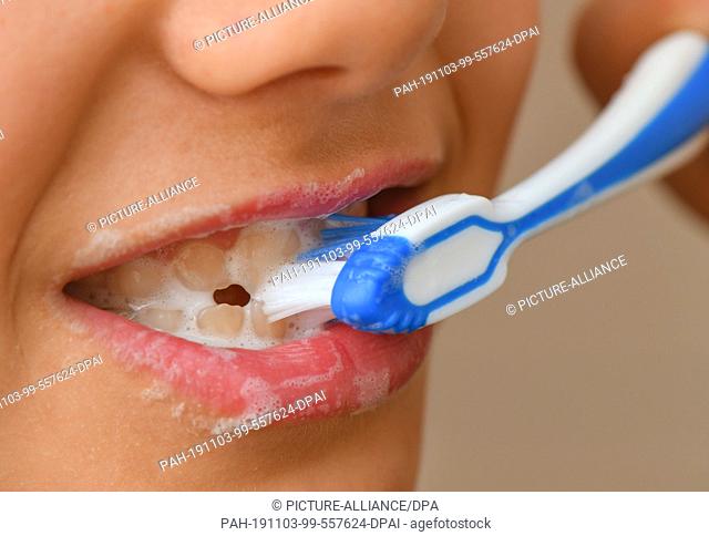 ILLUSTRATION - 02 November 2019, Brandenburg, Sieversdorf: A nine-year-old girl brushes her teeth with toothpaste. Berlin experts for dental health reach almost...