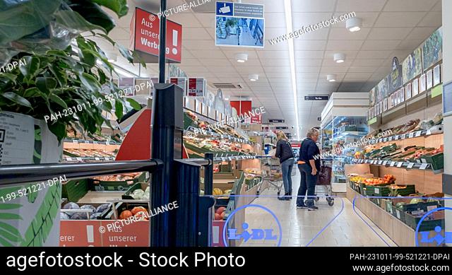 10 October 2023, Hamburg: Customers look at the range of vegetables and fruit on offer in a LIDL store, which is usually located directly at the entrance