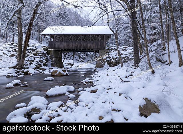 The Flume Covered Bridge in Franconia Notch, New Hampshire covered in snow during the month of December. This picturesque bridge crosses the Pemigewasset River