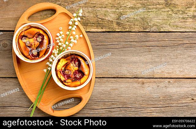cottage cheese dessert baked in portioned round ceramic plates on a wooden table, top view, copy space