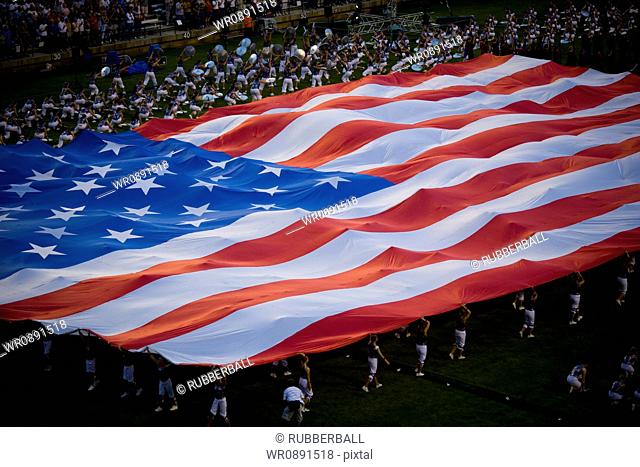 High angle view of a group of people holding a large American Flag