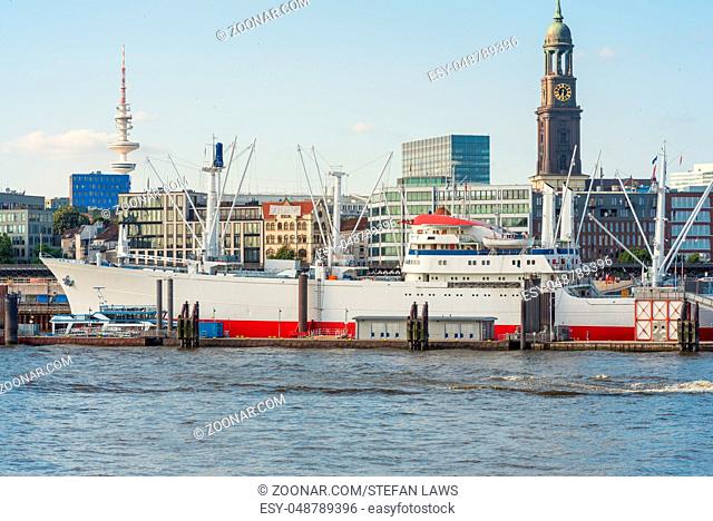 Skyline of the City seen from the right harbor side in Hamburg. Reefer ship in the harbor of Hamburg, The steeple of the famous St