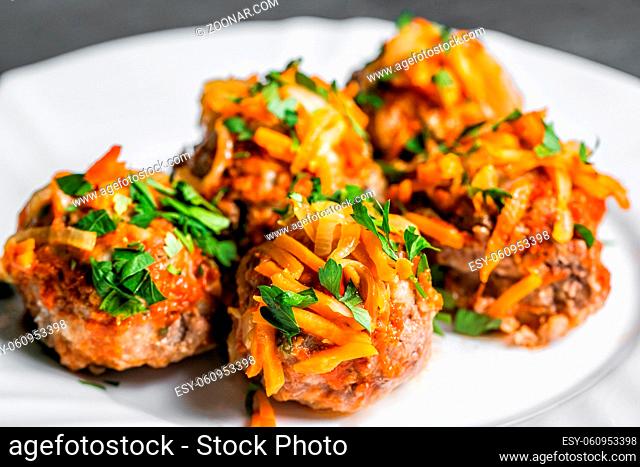 Delicious chicken or turkey meatballs with rice, vegetable in tomato sauce. white plate. selective focus