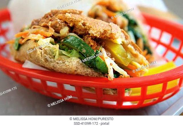 Close-up of a half eaten whole wheat sandwich in a basket