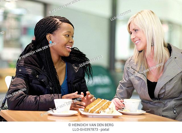 Two young women chatting at a coffee shop, Pietermaritzburg, KwaZulu-Natal, South Africa