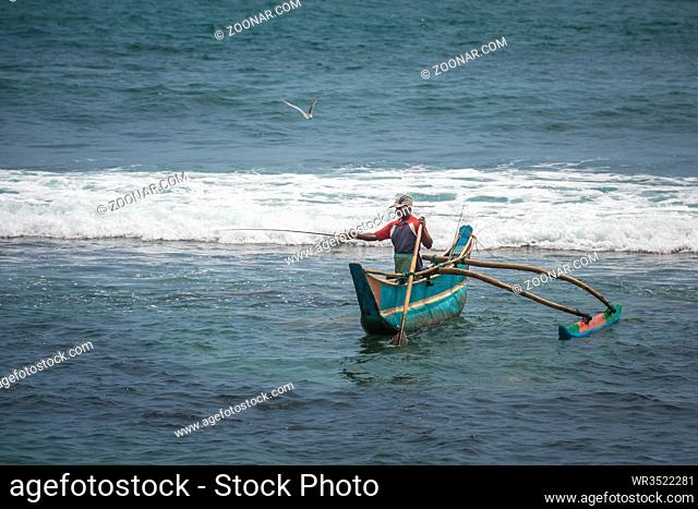 KOATTAGODA, SRI LANKA - February, 11, 2016: Sinhalese fishermen in traditional outrigger canoe