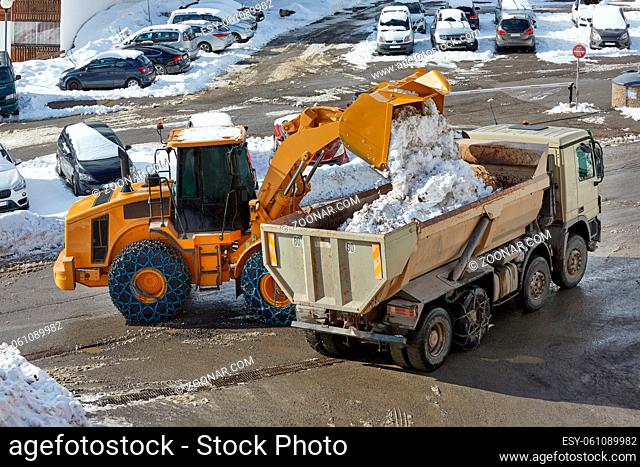 Removing snow from the road, loading on a dump truck