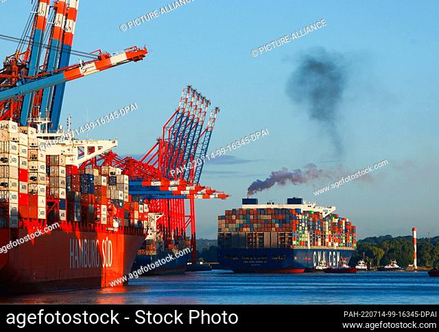 14 July 2022, Hamburg: The container ship CMA CGM Zheng He (r) of the shipping company CMA CGM docks at the Eurogate container terminal in Waltershofer Hafen