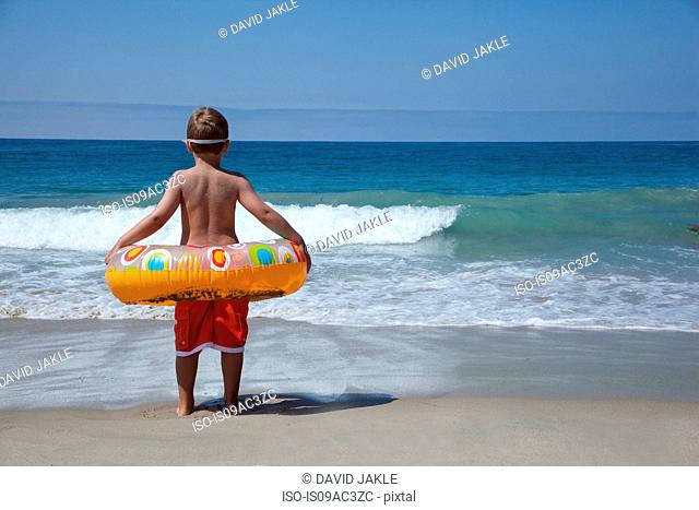 Young boy playing with rubber ring at beach