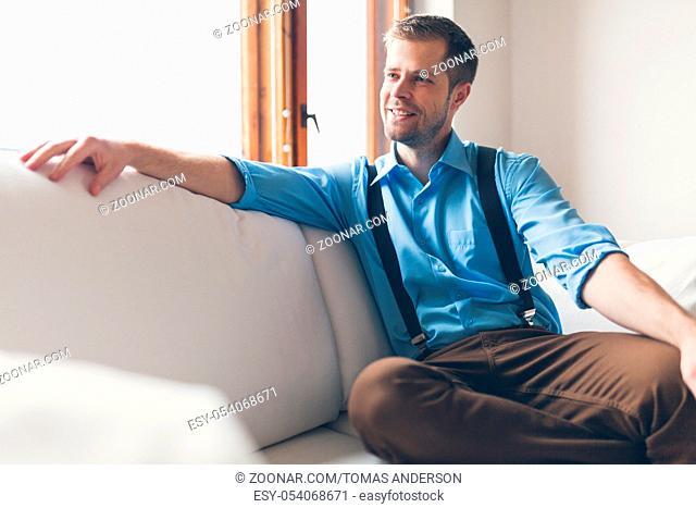 Man sitting and relaxin on sofa at home