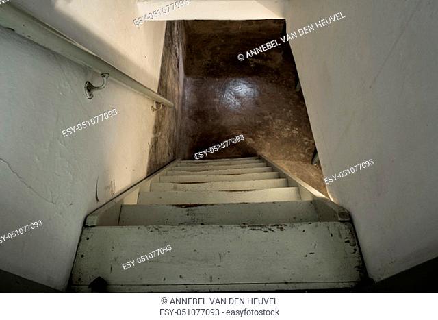 empty basement in abandoned old industrial building with little light and a wooden stairs darkness