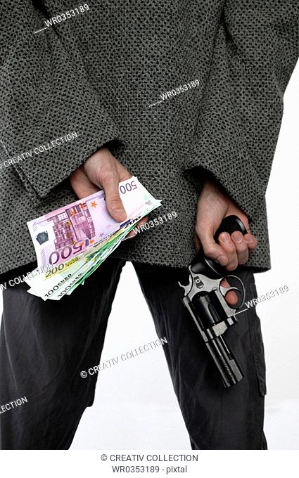 man holding a pistol and a bunch of money behind his back