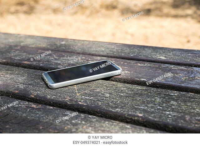 mobile phone lost on a table in the wood