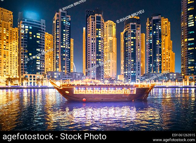 Tourist Boat, Sightseeing Boat Sailing On Dubai Marina At Nighttime. Night Walk Around residential district in Dubai Marina