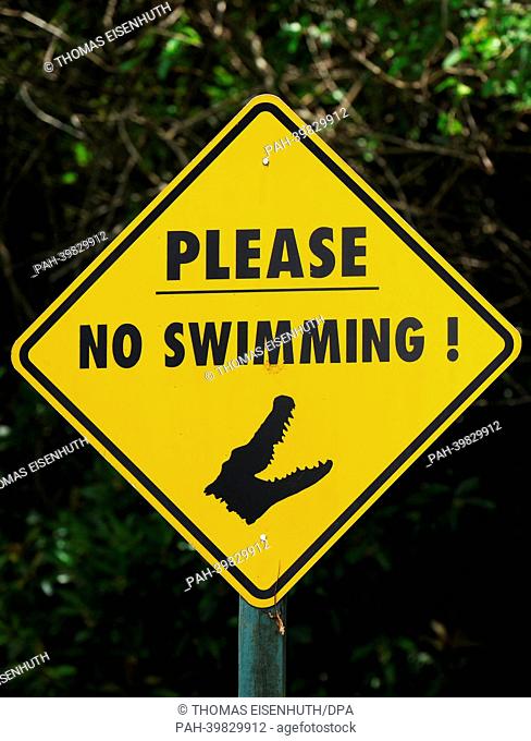 A sign warns people to not swim in the water, due to a nearby alligator farm of the Everglades National Park in Florida City, USA, 26 May 2013