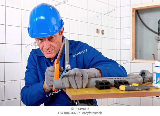 Builder sawing a tube