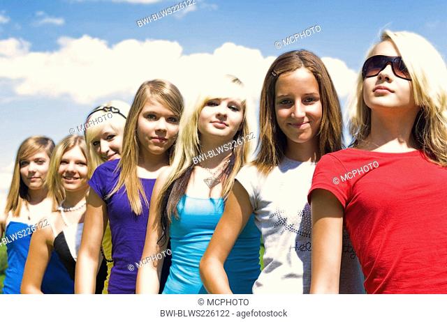 group of teenage girls standing in a row behind each other