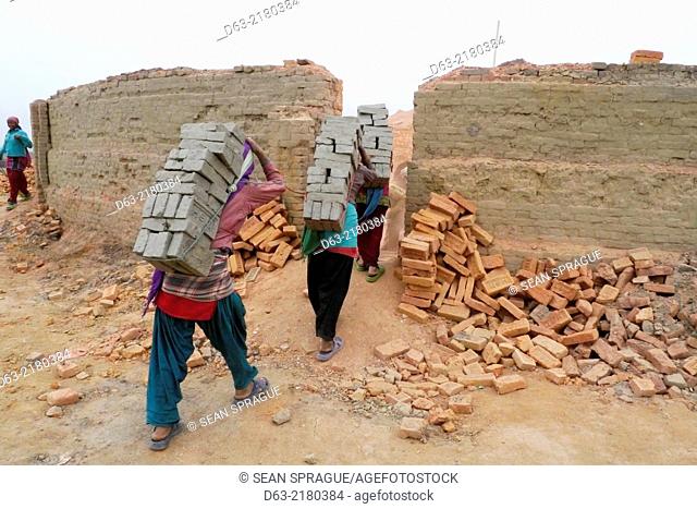 Nepal. Brickmakers at Godavari, Kathmandu Valley. Young women carying bricks to be fired