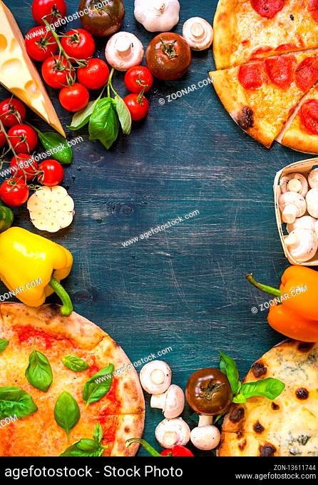 Pizza with assorted toppings and ingredients background. Space for text. Pizza, flour, cheese, tomatoes, basil, pepperoni
