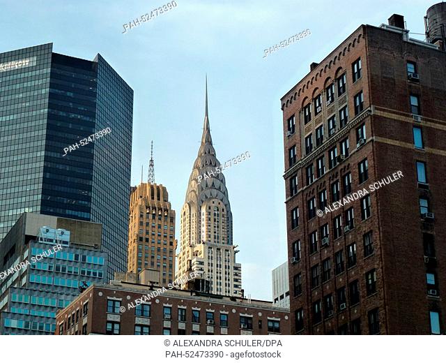 The top of the Chrysler Building juts out behind highrises on Manhattan, 24 June, 2014. This art deco-style building is one of the city's landmarks