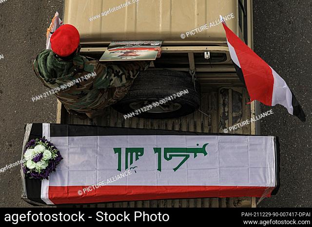 29 December 2021, Iraq, Baghdad: Members of the Iraqi predominantly Shia Muslim Popular Mobilization Forces (PMF) parade symbolic coffins at Baghdad's Tahrir...