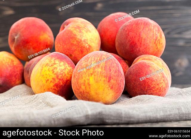 a bunch of ripe yellow-orange peach fruits on a linen napkin, closeup