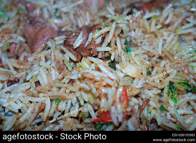 A close up view with selective focus of cooked white Basmati rice pulao or biryani with chicken meat