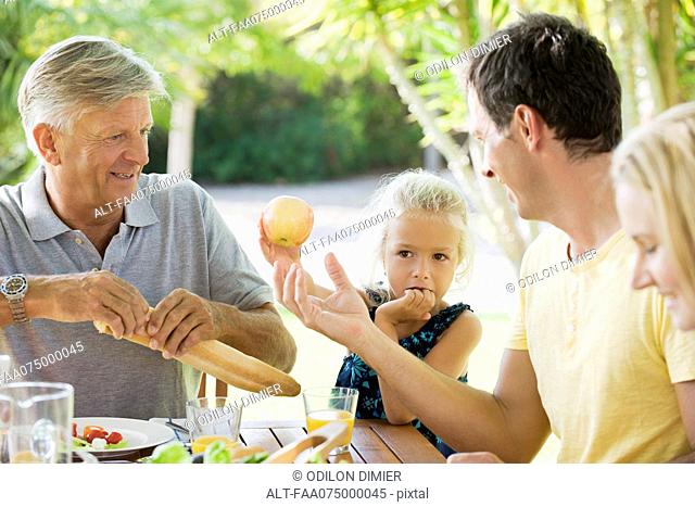 Multi-generation family having meal outdoors