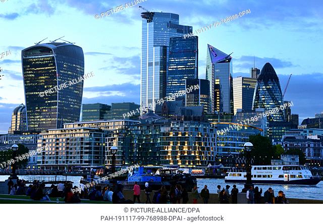 05 September 2019, Great Britain, London: View during the blue hour over the Thames to the skyscrapers in the London financial district