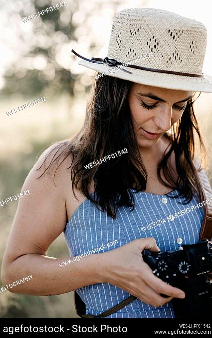 Woman wearing sun hat and using camera