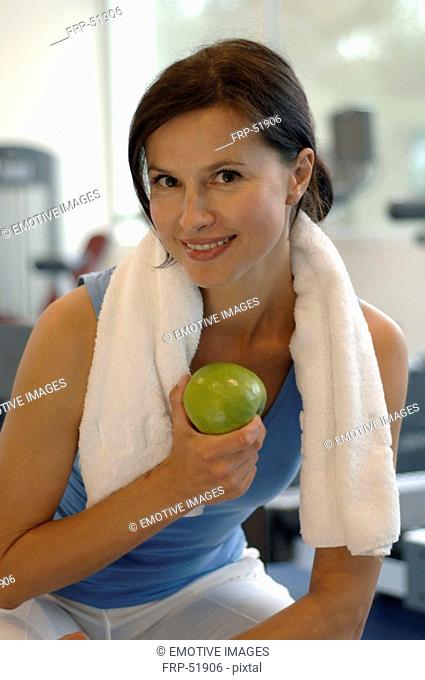 Woman in the gym eating an apple