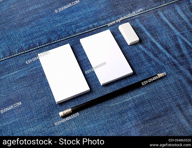 Photo of blank business cards, pencil and eraser on denim background. Stationery mock up. Template for placing your design