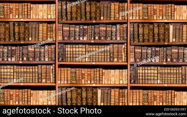 Defocused and blurred image of old antique library books on shelves for use in video conferencing background and sized to 16:9 format