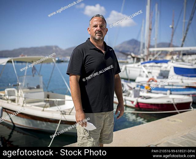 13 May 2021, Greece, Milos Island: Moraitis Dimitrios, vice president of hotels on the island of Milos, takes photos in the port town of Adamantas on the island