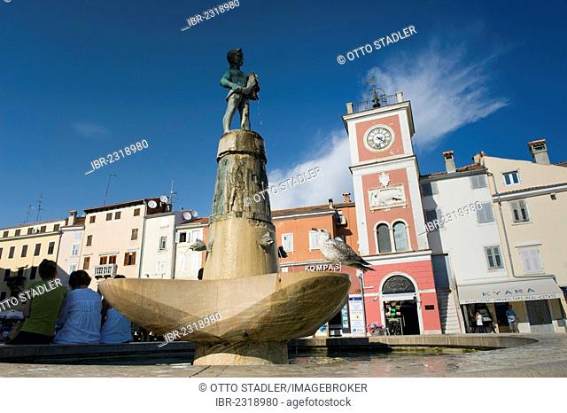 Figure on a fountain in front of the red clock tower in Rovinj, Istria, Croatia, Europe