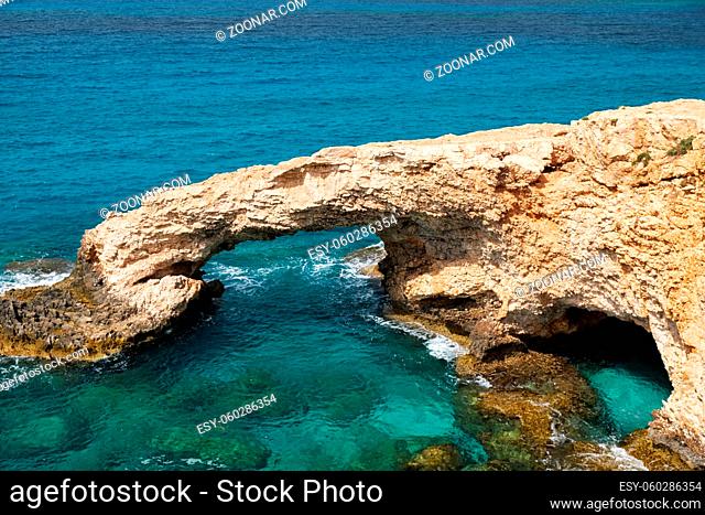 Love Bridge - a rocky arch bridge of natural origin over the crystal clear water of Cape Greco. Cyprus