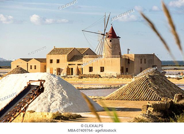 Pyramids of salt in front of Infersa windmill, on the coast connecting Marsala to Trapani, Trapani province, Sicily, Italy